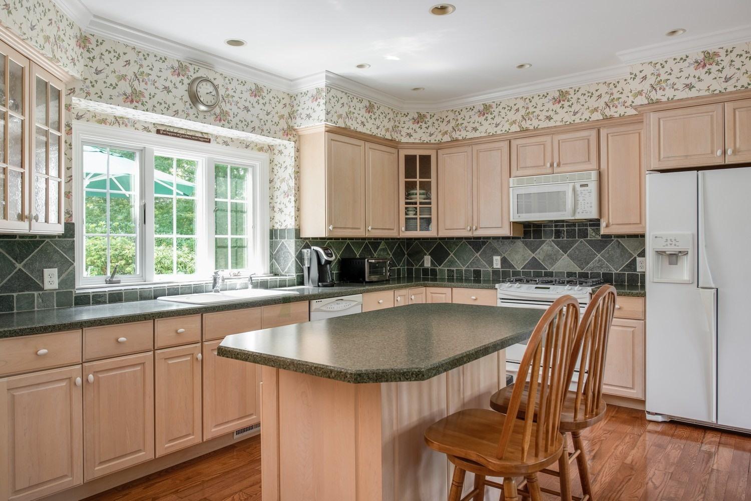 455 Turtleback Road Marstons Mills, MA 02648 - Photo 17 of 29 a kitchen with kitchen island granite countertop a sink and white cabinets