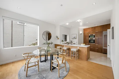 a view of a dining room and livingroom with furniture wooden floor and a rug