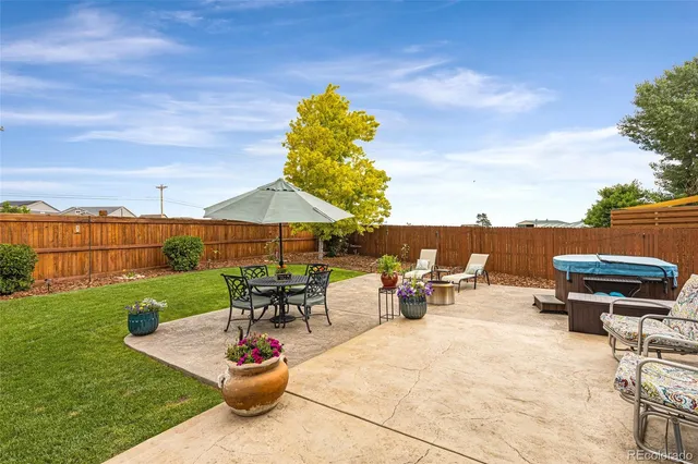 a view of a patio with a table and chairs under an umbrella