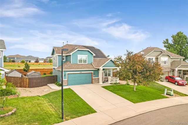 a front view of a house with a garden and yard