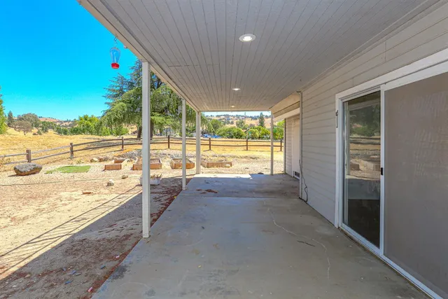 a view of a house with a small yard and a large tree