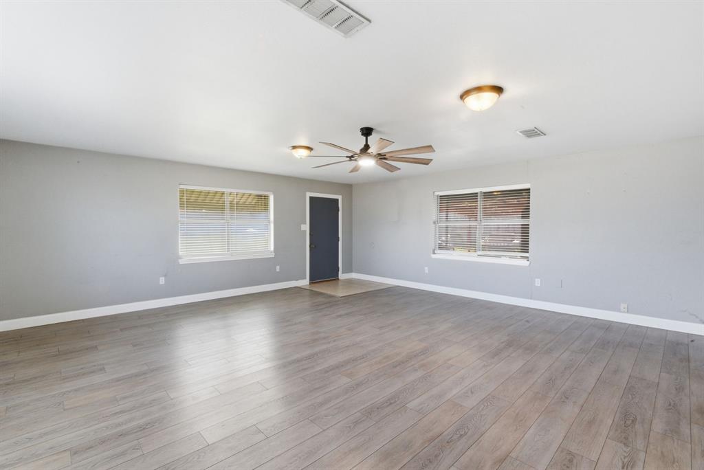 504 North Hall Street Hamilton, TX 76531 - Photo 15 of 31 an empty room with wooden floor chandelier and windows