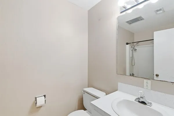 a bathroom with a sink mirror and toilet