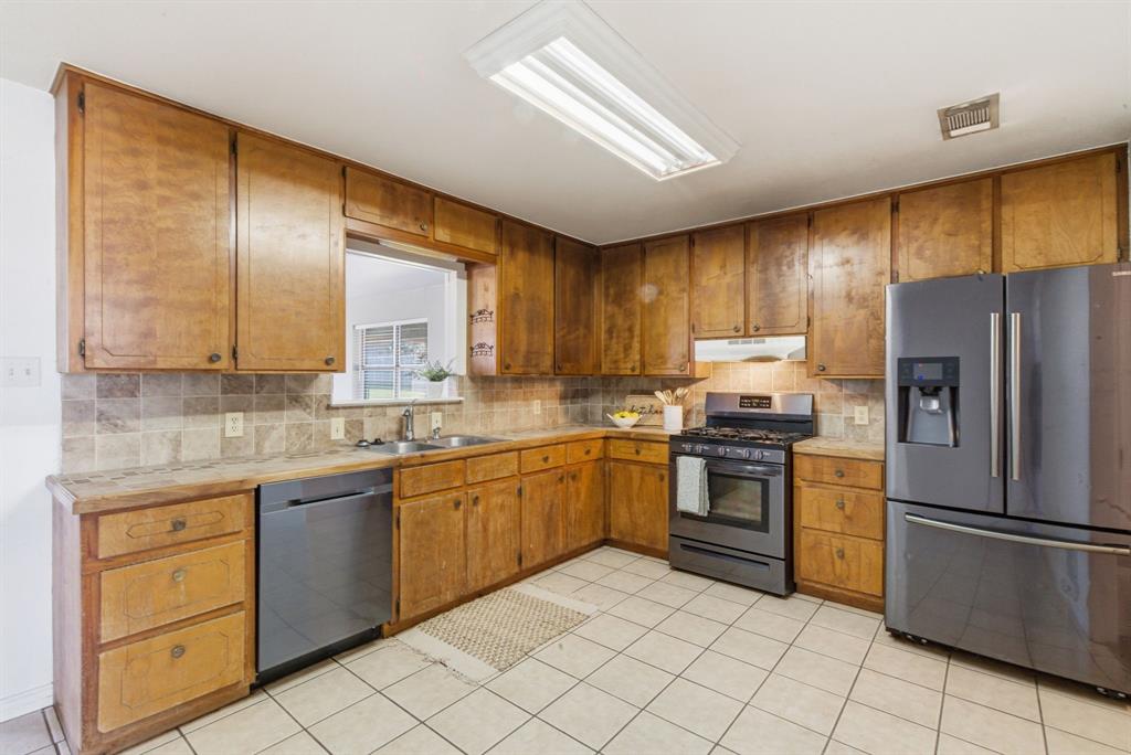 504 North Hall Street Hamilton, TX 76531 - Photo 8 of 31 a kitchen with stainless steel appliances granite countertop refrigerator sink and microwave