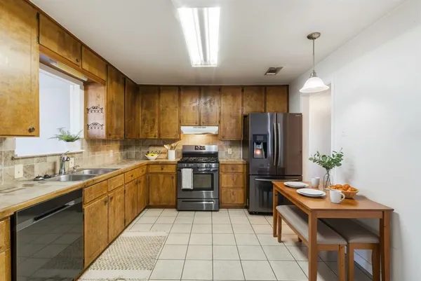 a kitchen with stainless steel appliances granite countertop a sink counter space cabinets and a window