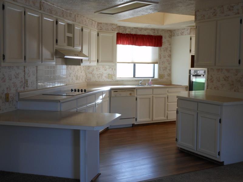 10073 Dalewood Way Grass Valley, CA 95949 - Photo 5 of 34 a kitchen with stainless steel appliances granite countertop a sink dishwasher a stove and white cabinets with wooden floor