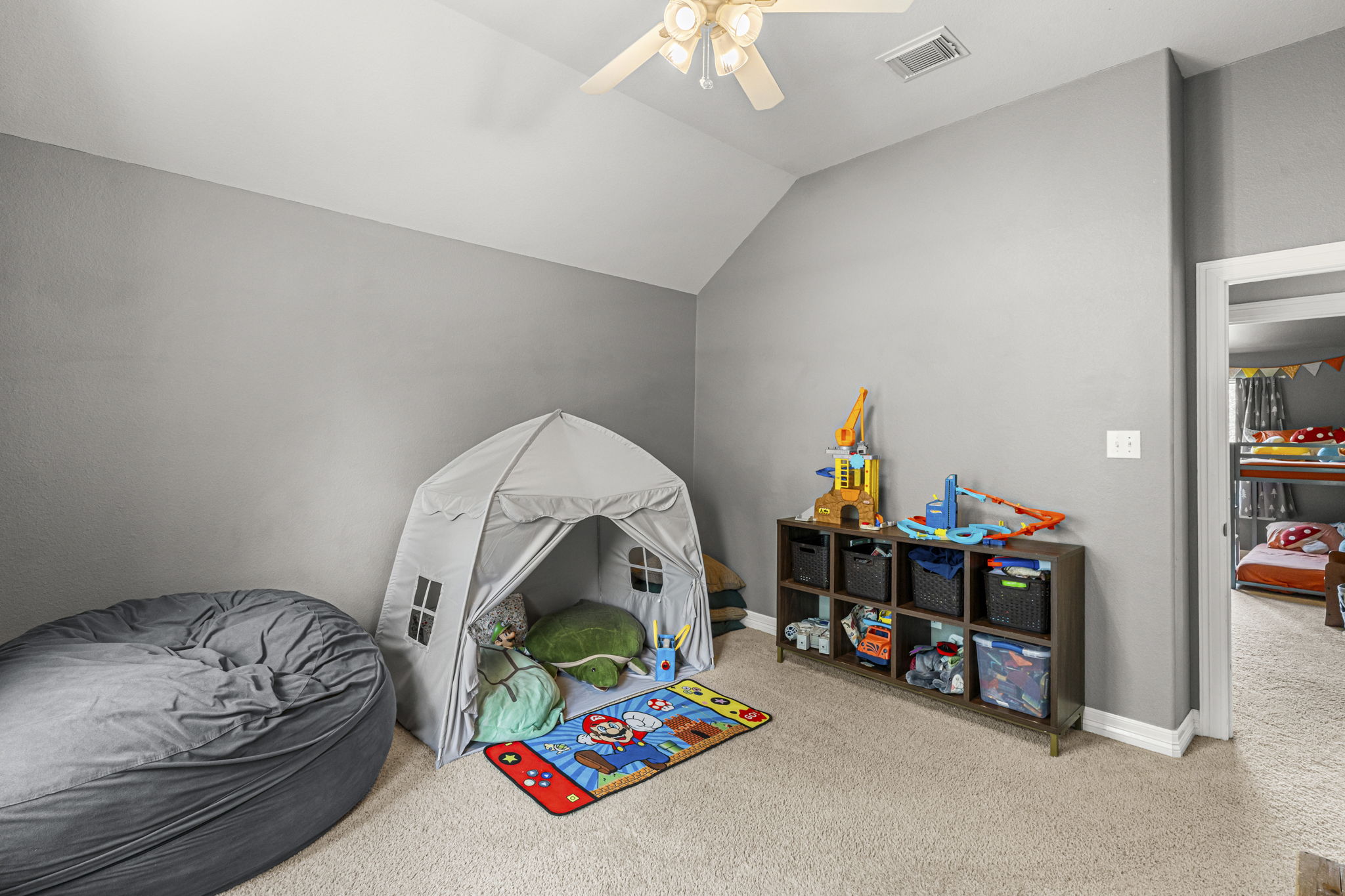 454 Fall Circle Kyle, TX 78640 - Photo 31 of 39 A cheerful bedroom with vaulted ceilings, creating an open and airy play space.