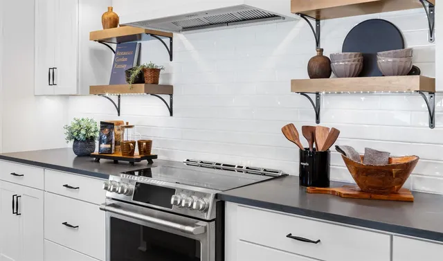 a kitchen with stainless steel appliances a table chairs in it and wooden floors