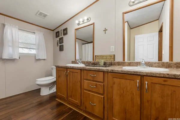 a bathroom with a granite countertop toilet sink and mirror