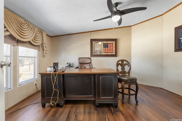 a view of a workspace with furniture and wooden floor
