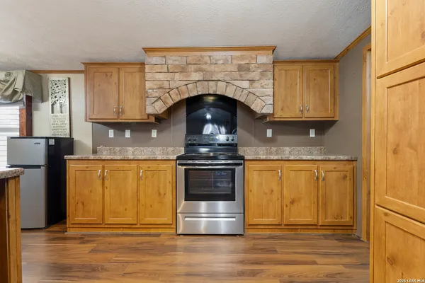 a kitchen with granite countertop a stove and a wooden floor