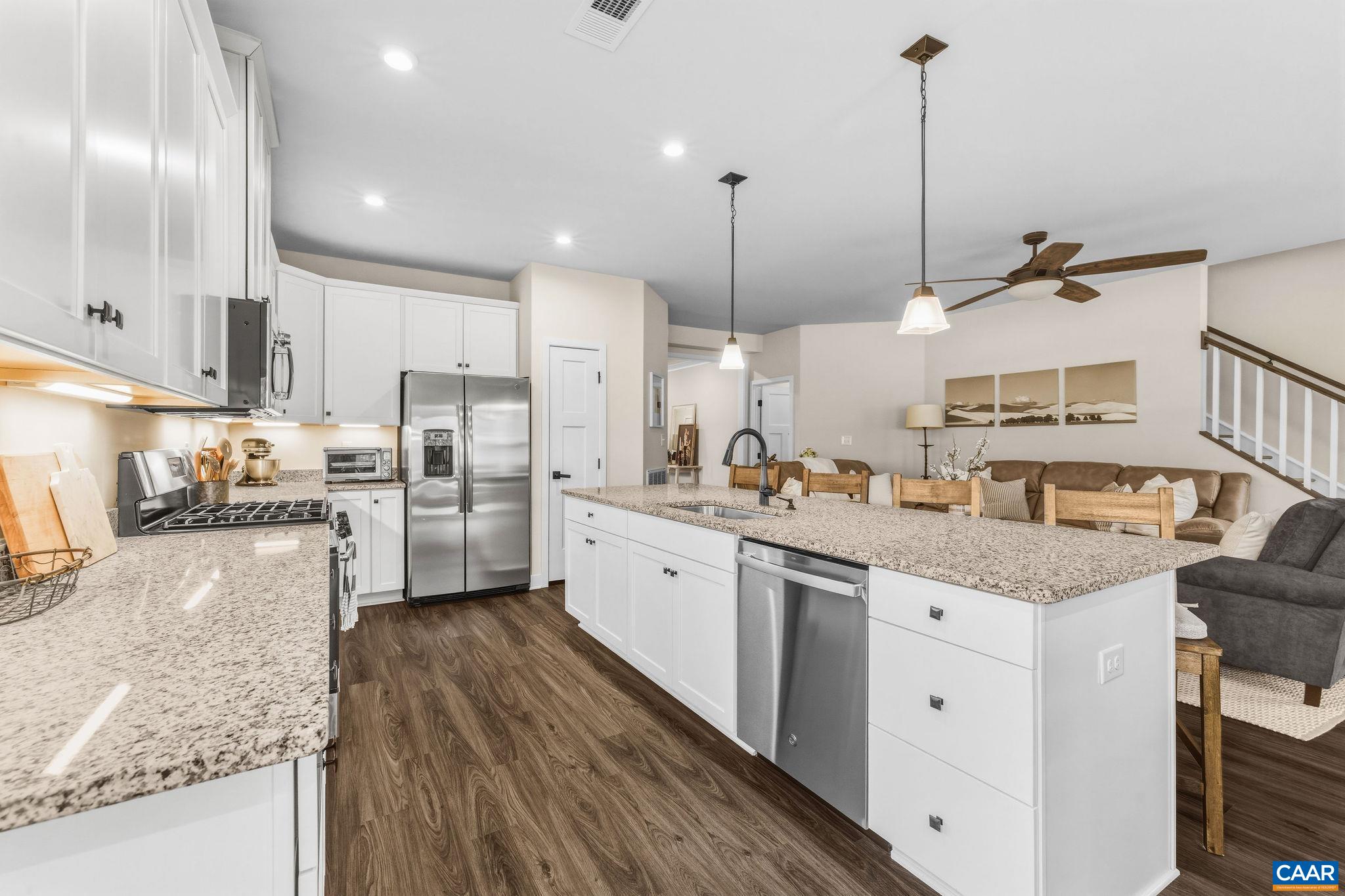 360 Winding Road Keswick, VA 22947 - Photo 21 of 48 a kitchen with stainless steel appliances granite countertop sink stove and white cabinets with wooden floor