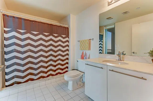 a bathroom with a sink and mirror with toilet
