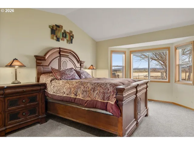 a bedroom with a bed and a dresser next to a window