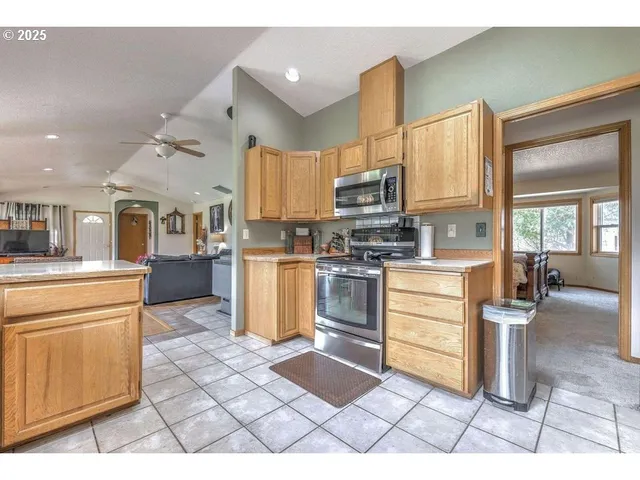 a kitchen with stainless steel appliances kitchen island granite countertop a refrigerator and cabinets