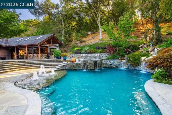 a view of a house with swimming pool and sitting area