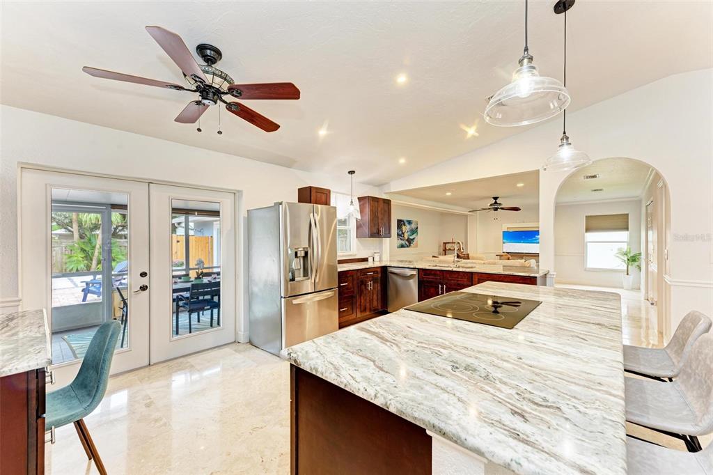 6715 12th Avenue Northwest Bradenton, FL 34209 - Photo 11 of 43 a kitchen with stainless steel appliances kitchen island granite countertop a refrigerator a sink dishwasher with a dining table and chairs with wooden floor
