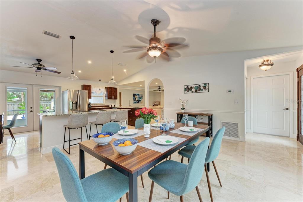 6715 12th Avenue Northwest Bradenton, FL 34209 - Photo 14 of 43 a dining room with wooden floor a chandelier fan a wooden table and chairs