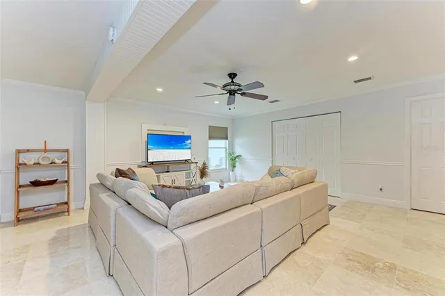 a living room with furniture and a ceiling fan