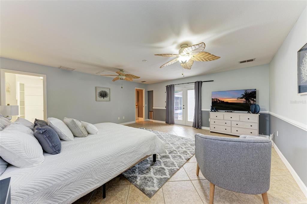 6715 12th Avenue Northwest Bradenton, FL 34209 - Photo 18 of 43 a bedroom with a bed and a chandelier