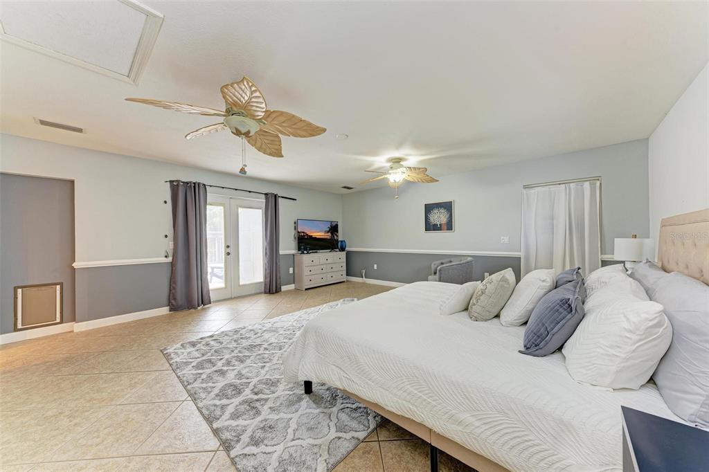 6715 12th Avenue Northwest Bradenton, FL 34209 - Photo 20 of 43 a bedroom with a large bed and a chandelier