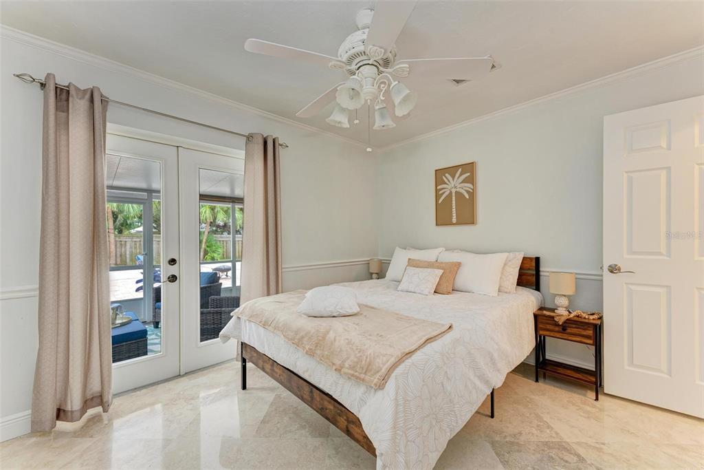 6715 12th Avenue Northwest Bradenton, FL 34209 - Photo 28 of 43 a bedroom with a large bed and a chandelier