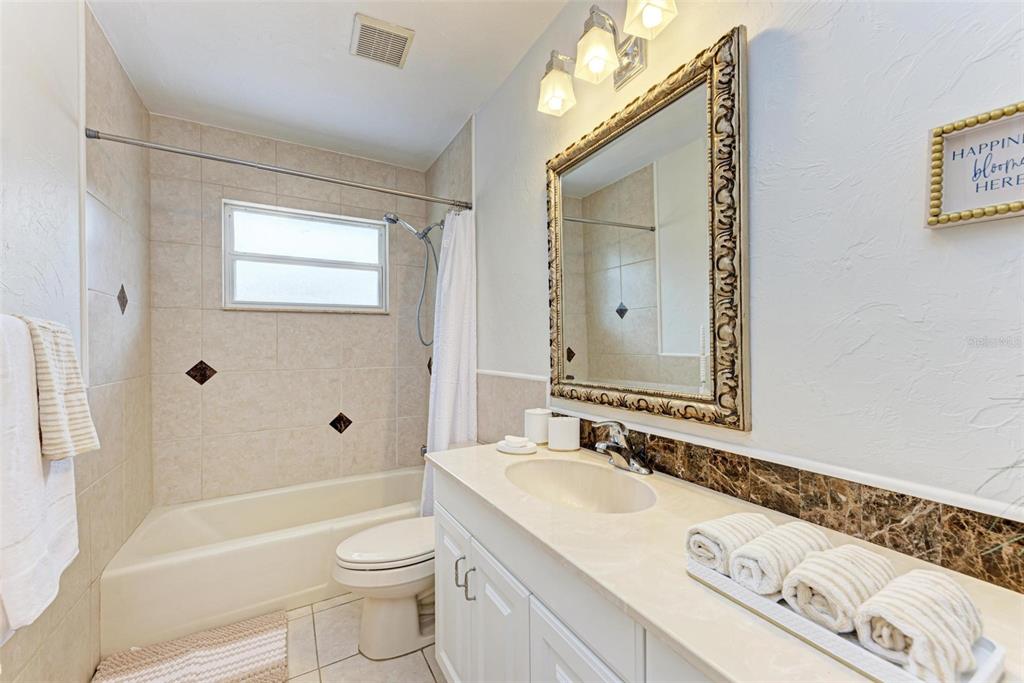 6715 12th Avenue Northwest Bradenton, FL 34209 - Photo 31 of 43 a bathroom with a granite countertop sink a toilet a mirror and shower