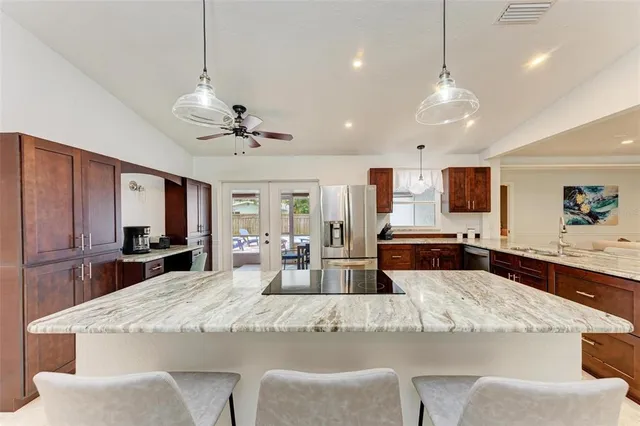a large kitchen with counter space a sink appliances and living room view