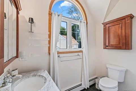 a bathroom with a toilet sink and mirror