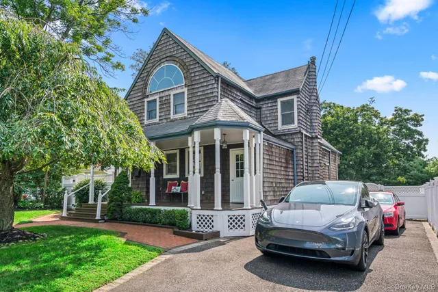 a front view of a house with a garden and trees