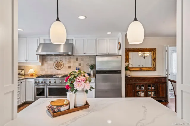 a kitchen with refrigerator and wooden floor