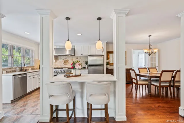 a view of a dining room and livingroom with furniture wooden floor a chandelier