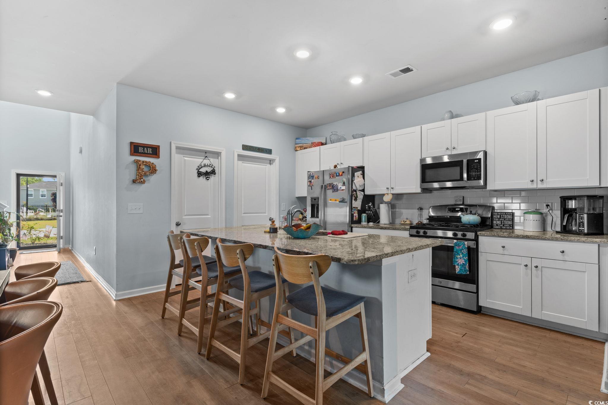 196 Cypress Tree Loop Longs, SC 29568 - Photo 5 of 40 Kitchen featuring stainless steel appliances, a kitchen island with sink, light wood-style floors, a breakfast bar, and recessed lighting