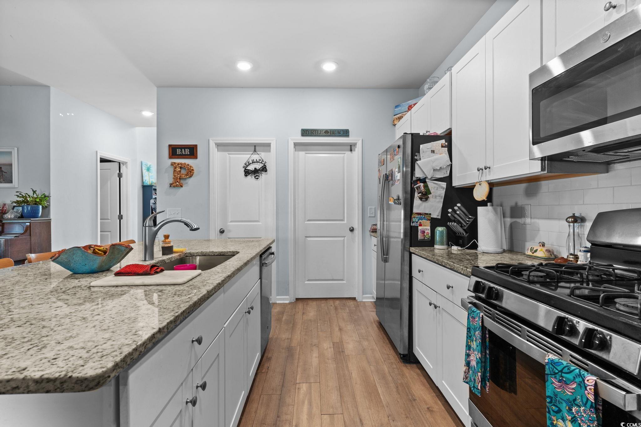 196 Cypress Tree Loop Longs, SC 29568 - Photo 6 of 40 Kitchen with appliances with stainless steel finishes, a sink, white cabinetry, tasteful backsplash, and recessed lighting