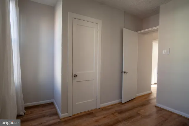 a view of empty room with wooden floor