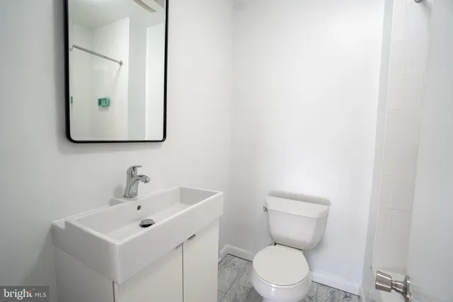 a white toilet sitting next to a bathroom sink