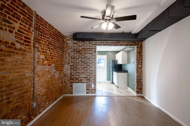 a view of a hallway with wooden floor and a ceiling fan