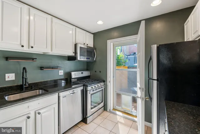 a kitchen with granite countertop a refrigerator and a sink