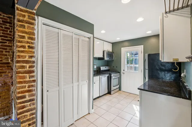 a kitchen with granite countertop a refrigerator and a sink