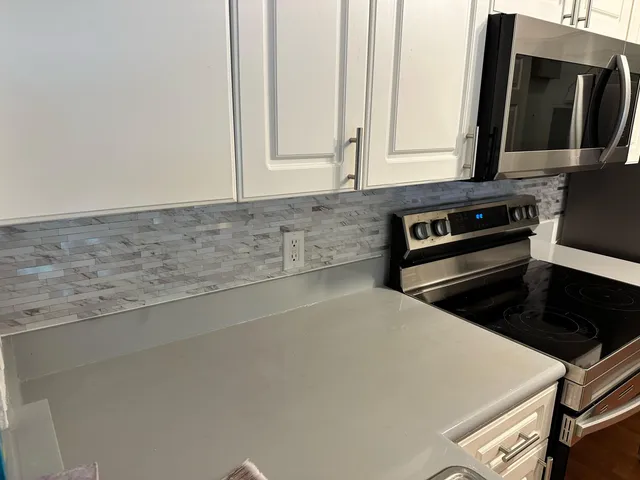 a kitchen with granite countertop a stove and a microwave
