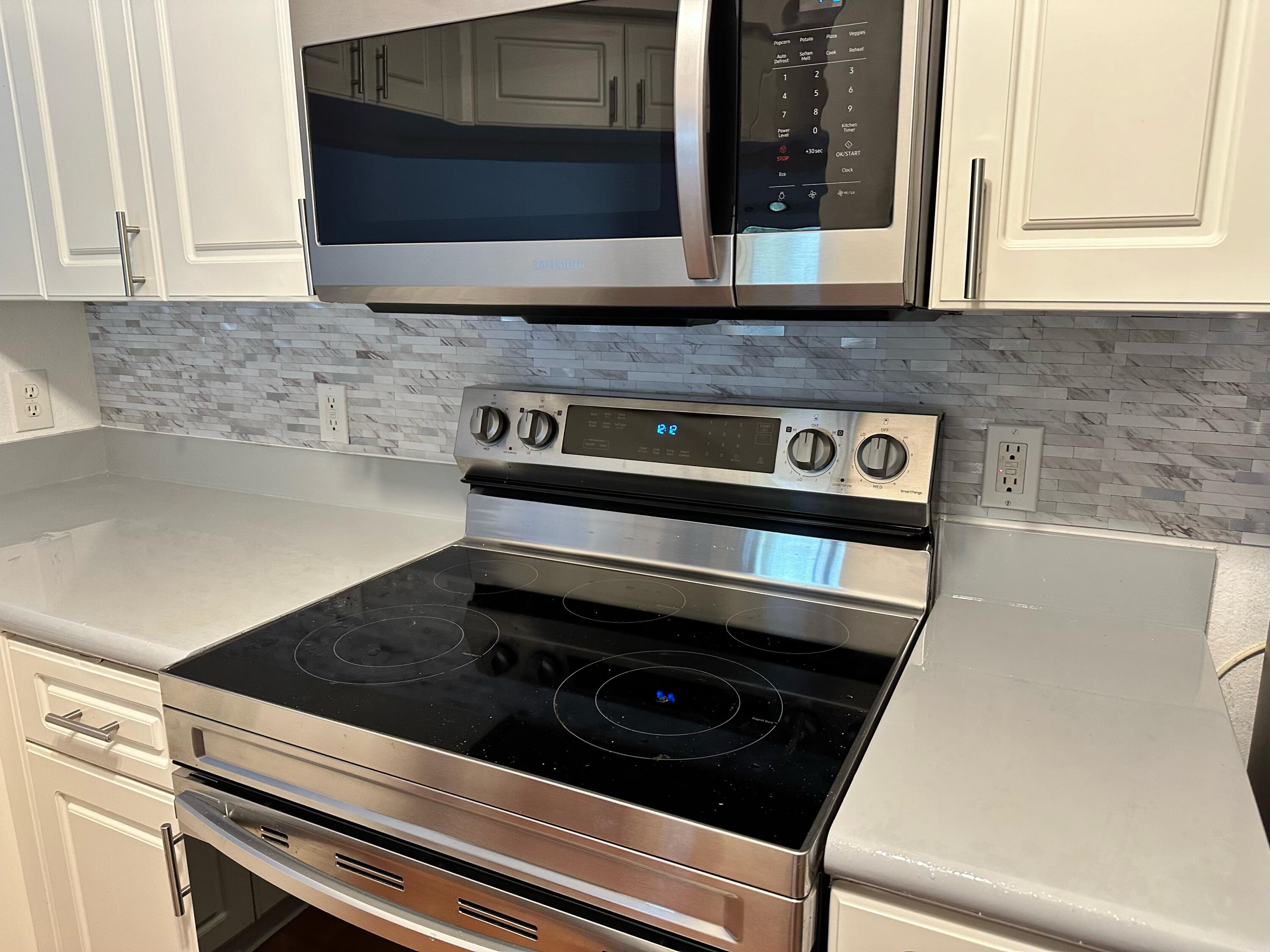 2725 Anzio Court, Unit 102 Palm Beach Gardens, FL 33410 - Photo 3 of 33 a kitchen with a stove and a microwave
