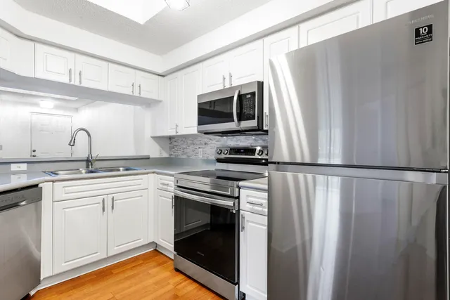 a view of a kitchen with a dishwasher and wooden floor