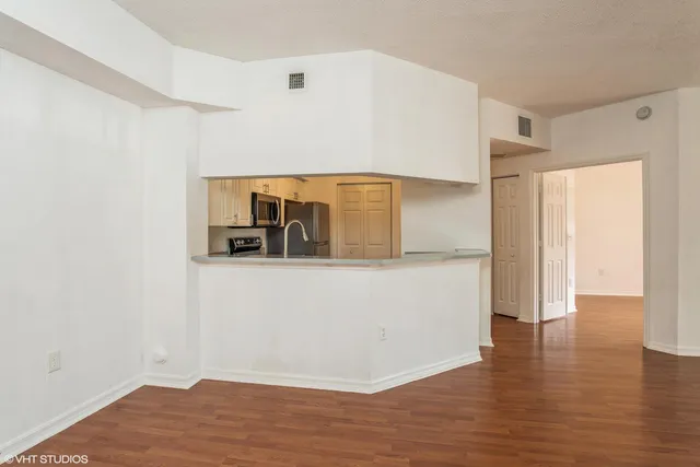 a view of empty room with wooden floor
