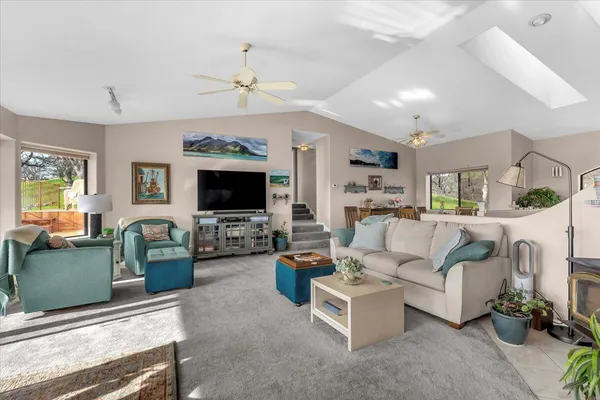 a living room with furniture a table and kitchen view