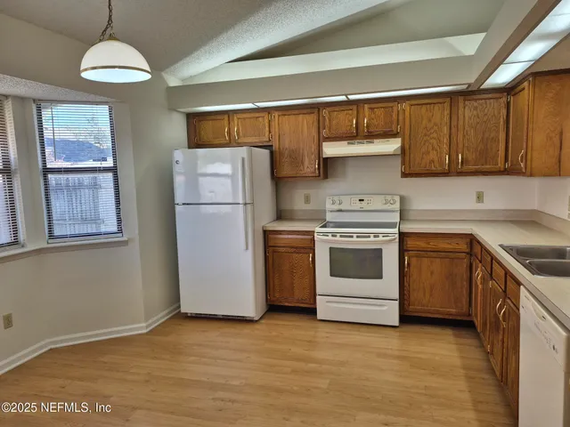 a kitchen with a stove cabinets and a refrigerator