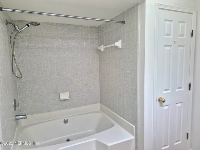 a bathroom with a shower and a bath tub