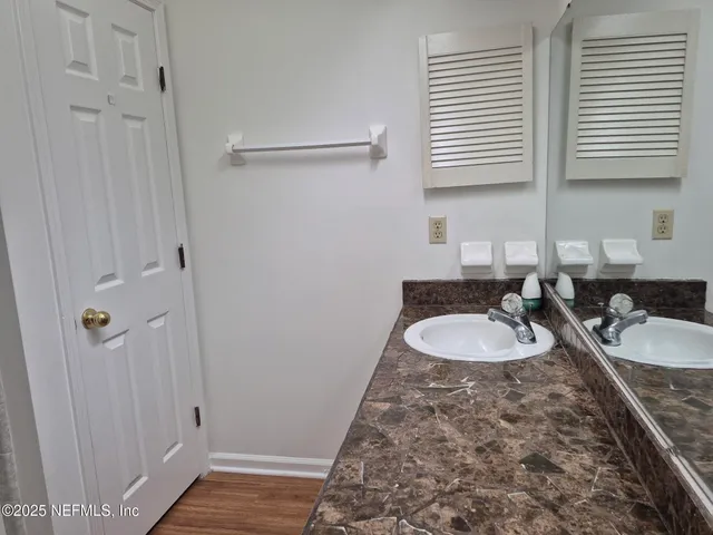a bathroom with double vanity sink and two mirror