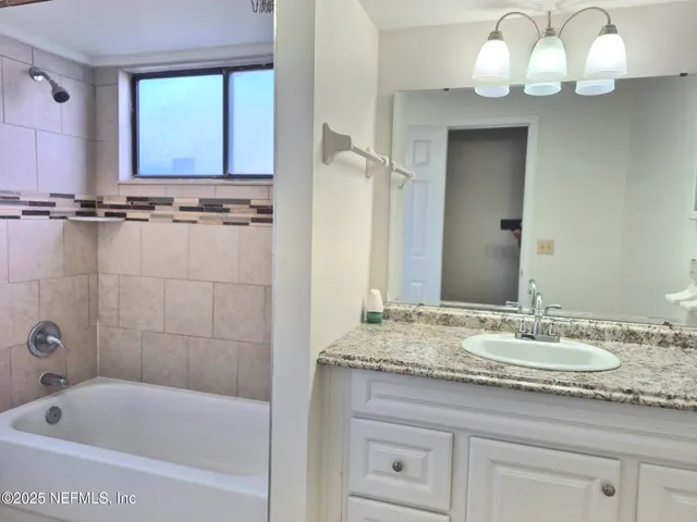 a bathroom with a sink a tub and a mirror