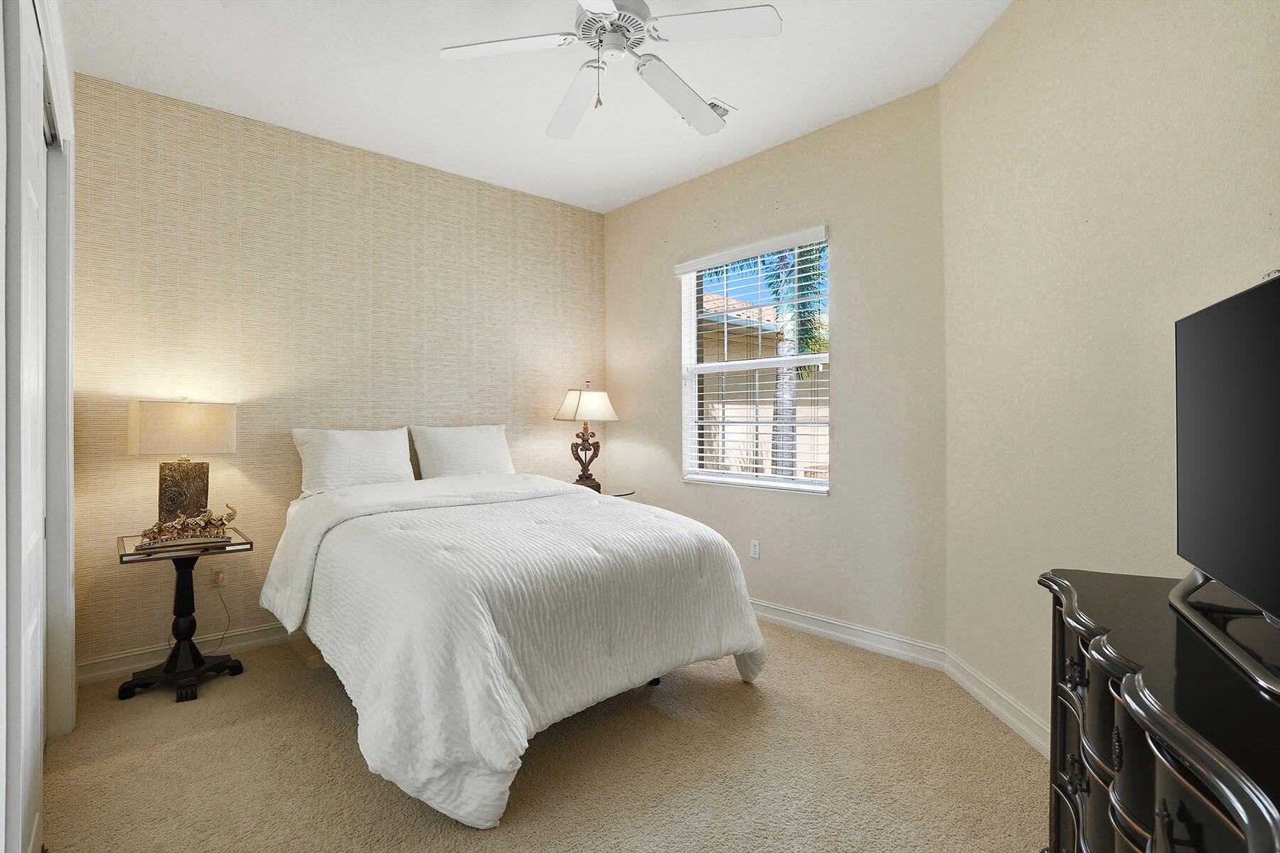 8605 Champions Point, Unit 103 Naples, FL 34113 - Photo 29 of 44 a bedroom with a bed and a flat tv screen on a dresser