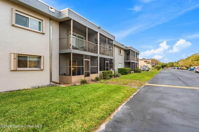 a view of a house with a yard and pathway